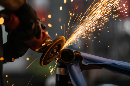 Worker,Cutting,,Grinding,And,Polishing,Motorcycle,Metal,Part,With,Sparks